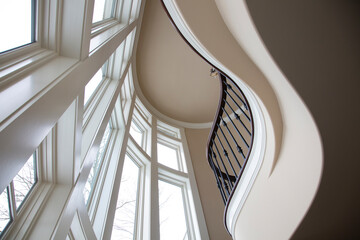 Beautiful staircase in a circular shape with giant windows from floor to ceiling