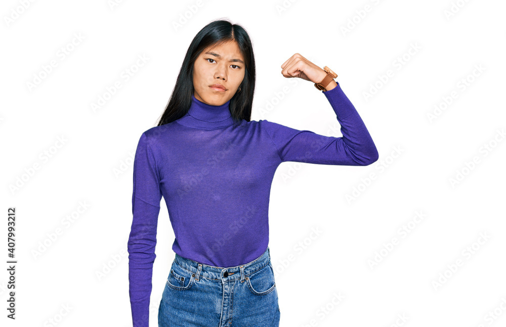 Sticker Beautiful young asian woman wearing casual clothes strong person showing arm muscle, confident and proud of power