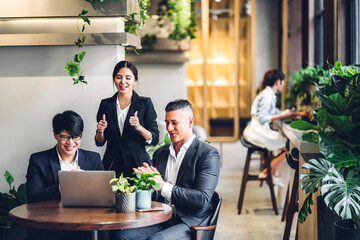 Group of professional multiethnic teamwork business discussing meeting strategy sharing idea with new startup project.Creative business people working with laptop computer in green plant terrace 