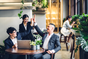 Successful of group professional business people to win of celebrating project success.Creative business happy and enjoy gesture hand high five good teamwork together at green plant terrace workloft