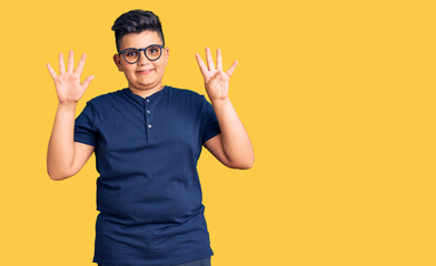 Little boy kid wearing casual clothes and glasses showing and pointing up with fingers number nine while smiling confident and happy.