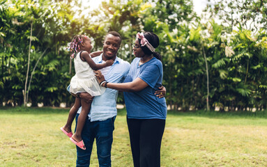 Portrait of enjoy happy love black family african american father and mother with little african girl child smiling and play having fun moments good time in summer park at home