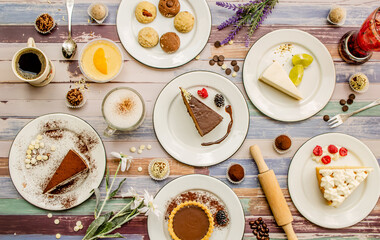 Dessert table with variety of cakes, pies, cookies and coffee on flat lay view.