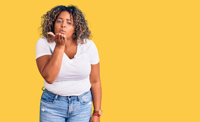 Young african american plus size woman wearing casual clothes looking at the camera blowing a kiss with hand on air being lovely and sexy. love expression.