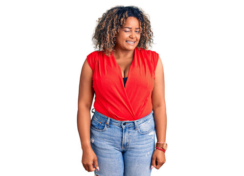 Young african american plus size woman wearing casual style with sleeveless shirt winking looking at the camera with sexy expression, cheerful and happy face.