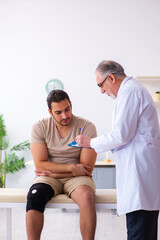Fototapeta premium Experienced doctor traumatologist examining young male patient