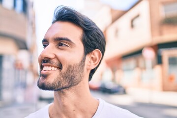 Young hispanic man smiling happy walking at the city.