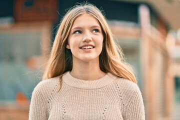Beautiful caucasian teenager smiling happy standing at the city.
