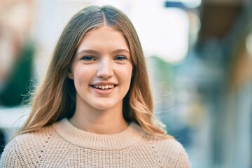 Fototapeta premium Beautiful caucasian teenager smiling happy standing at the city.