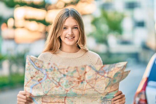Beautiful caucasian tourist teenager smiling happy holding map at the city.