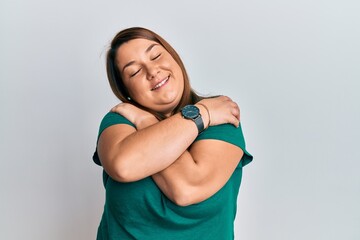 Fototapeta na wymiar Beautiful brunette plus size woman wearing casual clothes hugging oneself happy and positive, smiling confident. self love and self care