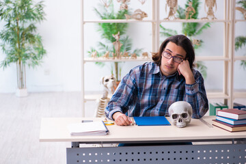 Young male teacher paleontologist in the classroom