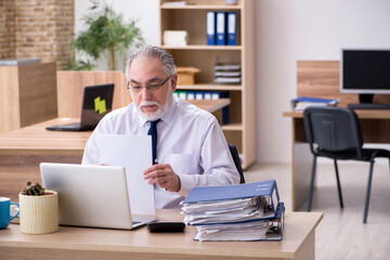 Old male employee working in the office