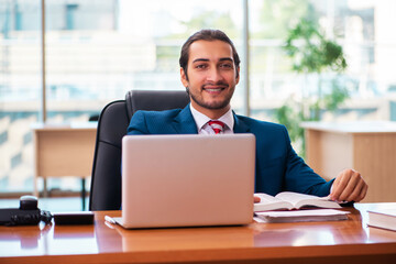 Young handsome employee working in the office