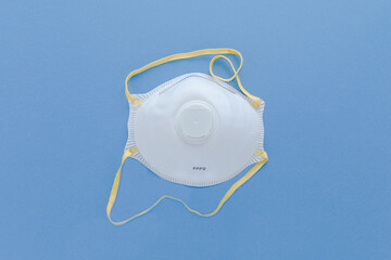 White FFP2,  N95  Industrial Respirator  filter Safety mask isolated on blue background. Protection from bacterias and virus,  included Covid-19