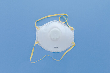 White FFP2,  N95  Industrial Respirator  filter Safety mask isolated on blue background. Protection...