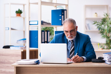 Old male bookkeeper unhappy with excessive work at workplace