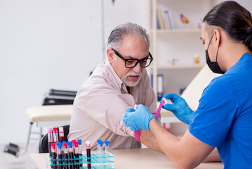 Old patient visiting young male doctor in blood transfusion conc