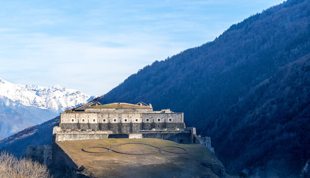 Exilles Fort is a fortified complex in the Susa Valley, Metropolitan City of Turin, Piedmont, northern Italy. Medieval fortress wall towers view. Medieval fort landmark. Fortress on winter sunny day.