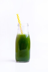 Green vegetable juice in the glass bottle  at white background. 