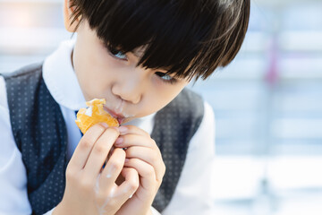 Cute little child love eating sweets or ice cream. Handsome little boy enjoy eating ice cream so much in city. Adorable kid like eating delicious sweets. He feel happy when he eat favorite dessert
