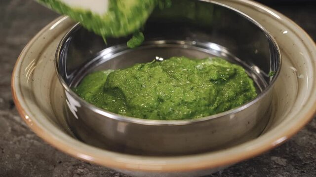 Chef cooking green sauce. Cooking sauce for a meat dish. Sauce made with fresh herbs. 