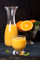 glass of fresh orange juice with fresh fruits on wooden