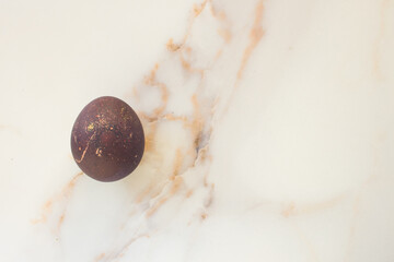 Minimal easter concept of brown egg. Stylish Easter brown on white marble background. The flat lay fashionable easter. Happy easter card with copy space for text