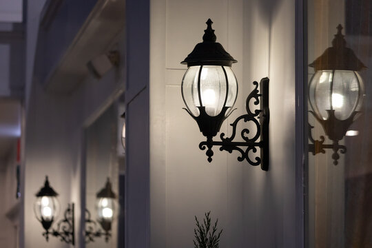 Wrought-iron Wall Lamp Of Outdoor Building At Night Time.