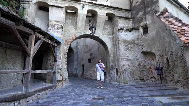 Young man admire, sightseeing old medieval city in Romania