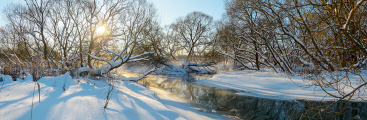 Fototapeta na wymiar Frosty winter landscape with forest river during sunny january morning