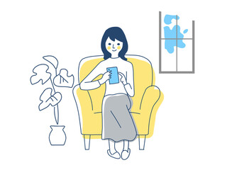 ソファーでスマートフォンをを操作する女性