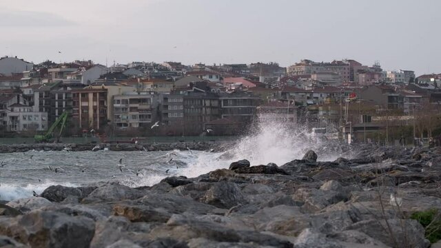 The waves crashing into the rocks in slow motion and flying seagulls in a stormy day at Istanbul Kadikoy Kalamis. There are two clip parts.