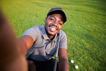 Black golfer takes a selfie on an outdoor golf course.