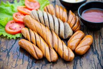 Fried sausages recipe with fresh tomato and sauces ketchup ready to be served, international food style concept