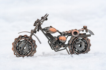 Obraz na płótnie Canvas Metal model toy sports motorcycle stands on a snowy road, white background