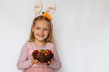 Cute little girl with bunny ears holding Easter egg, isolated on white background. Adorable child celebrate Easter holiday