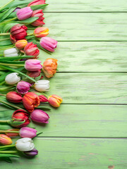 Colorful  bouquet of tulips on green wooden background.