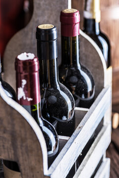 Wine bottles in wooden crate and oak wine keg.