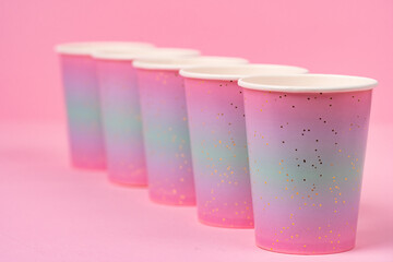 Pink disposable paper cups on pink background
