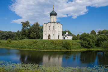 View of the Church of the Intercession on the Nerl and the Church of the Three Saints of the Ecumenical on a sunny summer day. Bogolyubovo. Vladimir region, Russia