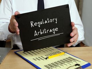 Business concept about Regulatory Arbitrage with sign on the page.
