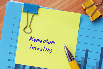  Financial concept meaning Momentum Investing with sign on the piece of paper.