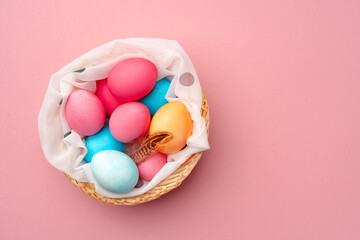 Painted Easter eggs in decorative nest on pink background
