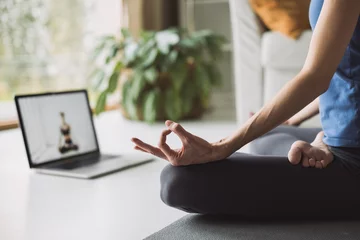 Dekokissen Young woman practicing yoga at home, online video training, Girl doing exercises and meditate, Yoga, balance, meditation, relaxation, healthy lifestyle, online training class concept © kite_rin