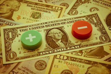 Plus and Minus symbol on US dollar banknotes background. The Federal Reserve ( FED ) to cut or raises interest rates concept. Global world economy crisis, U.S. vs China trade war or currency war.