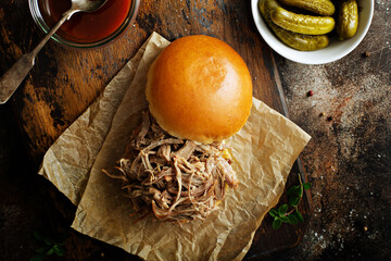 Pulled pork sandwich on a soft brioche bun with bbq sauce and pickles