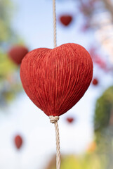 Red heart shape mobile hanging, handcraft for home and garden decoration, or valentine's day on blurred background.