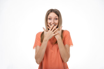 Worried blond girlcover opened mouth palms and looking with surprised expression. Studio shot, white background