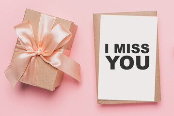 Gifts with note letter on isolated pink background, love and valentine concept with text I miss you